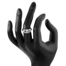 Prsten ve stříbrné barvě, rozdělená ramena se zirkonovými lístky, čirý ovál