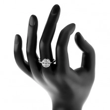 Lesklý prsten stříbrné barvy, kruh zdobený čirými zrnky a kulatým zirkonem