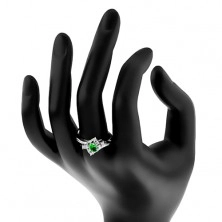 Prsten ve stříbrné barvě, oválný tmavě zelený zirkon, zářezy na ramenech