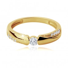 Prsten z 9K zlata - kulatý zirkon v zaobleném výřezu, ramena zdobená linií zirkonů